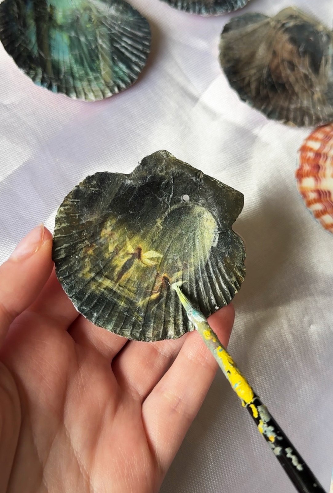 Elizaveta painting on a seashell